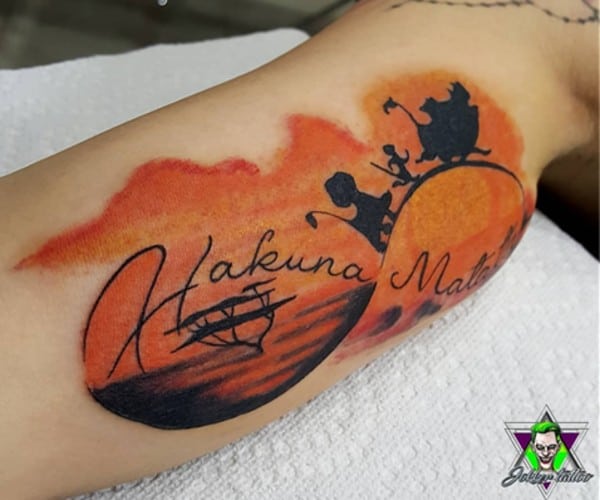 tatuaggio hakuna matata arancione sul braccio