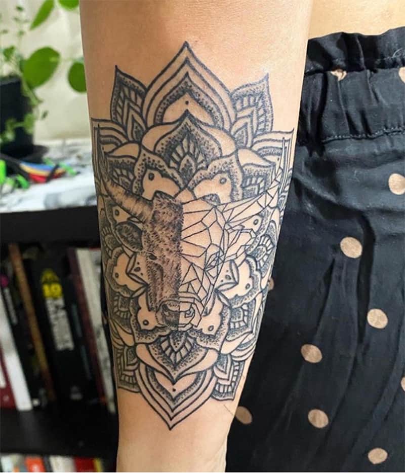 tatuaje mitad realista mitad geométrico de tauro en el brazo