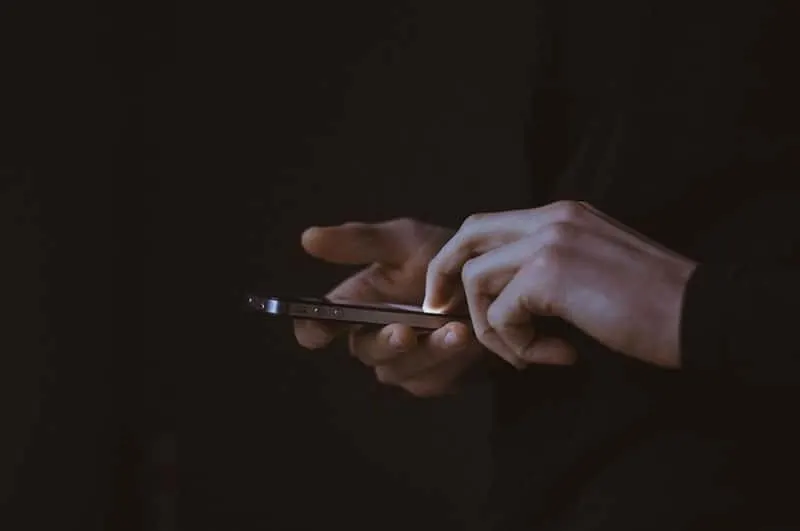 hand on the phone scrolling in dark place
