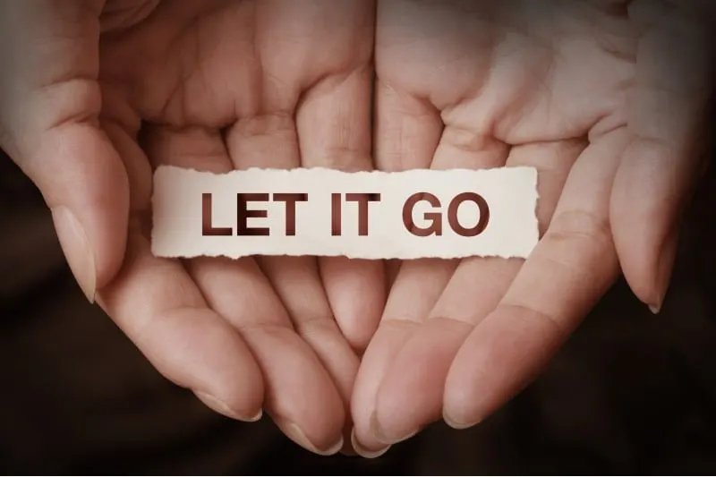 Hands holding let it go message written on paper