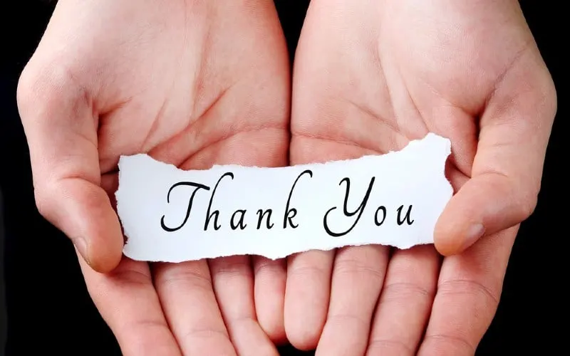 Hands honding paper with thank you message