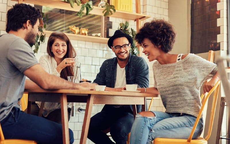 Two men and two women looking happy sitting at a table