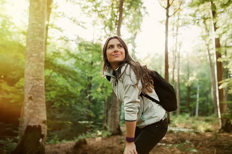 happy woman hiking in woods