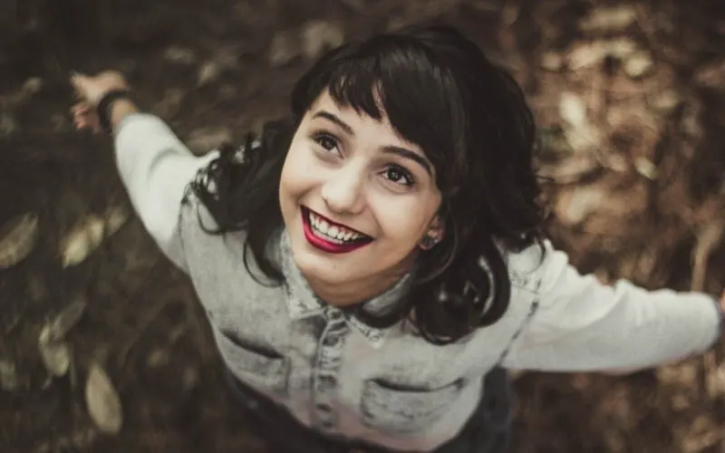 Young happy woman wearing denim jacket looking up