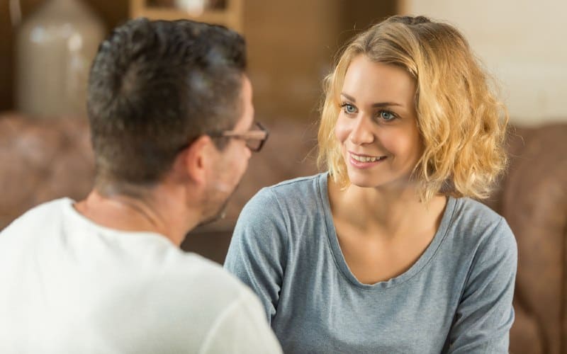 Happy woman sitting in front of a man and talking