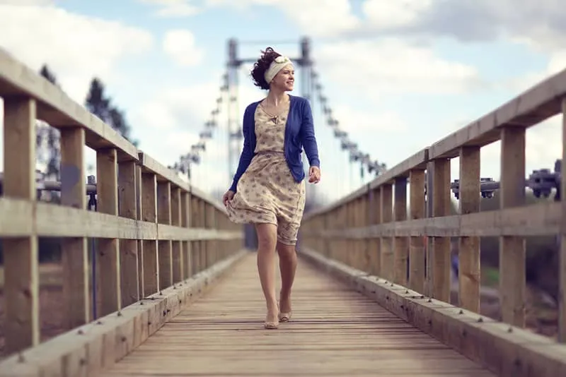 happy woman walking across the bridge