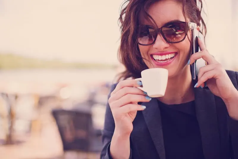 happy woman wearing sunglasses and cup of coffee
