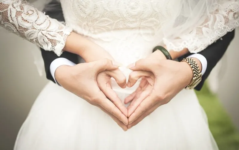 Heart shaped hands of bride and groom