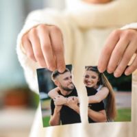 Una mujer rompe una foto de una pareja feliz