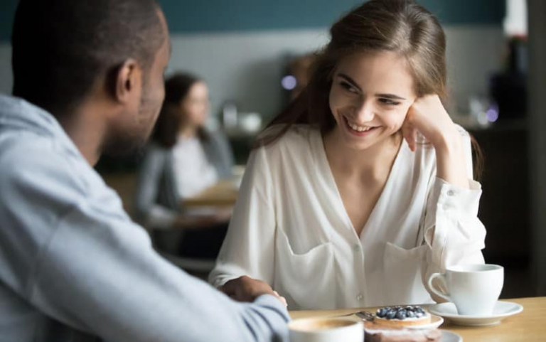 Smiling woman sitting in front of a man a a table