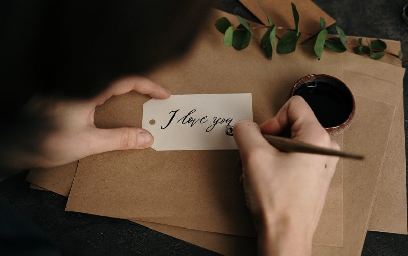 Donna che scrive un messaggio d'amore su un foglio di carta