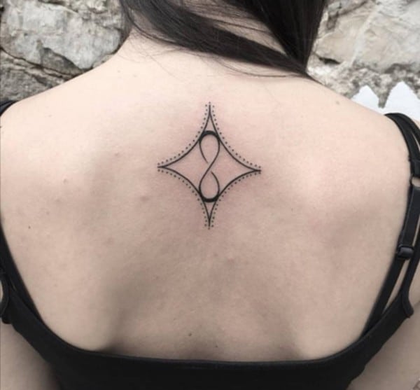 tatuaggio con segno dell'infinito con dettagli punteggiati a rombo invertito