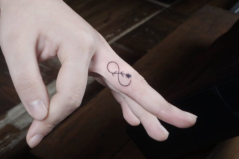 tatuaje infinito con flor en el dedo