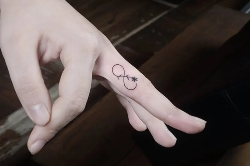 infinity tattoo with flower on the finger