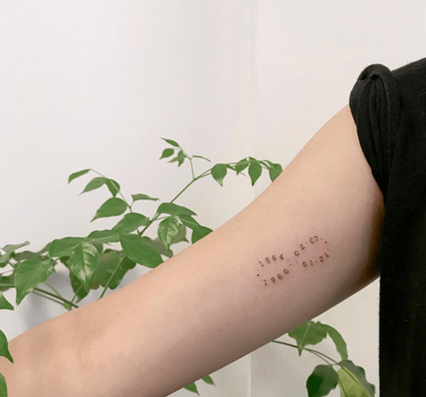 tatuaggio infinito con date sul braccio