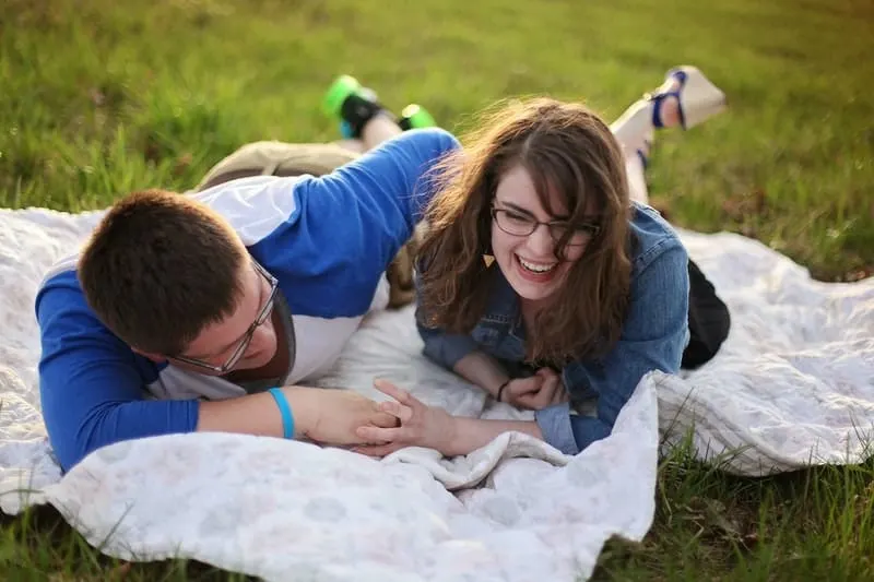laughing couple on picnic mat wearing denim tops