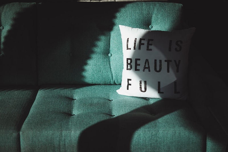 life is beautifull throw pillow on top of sofa