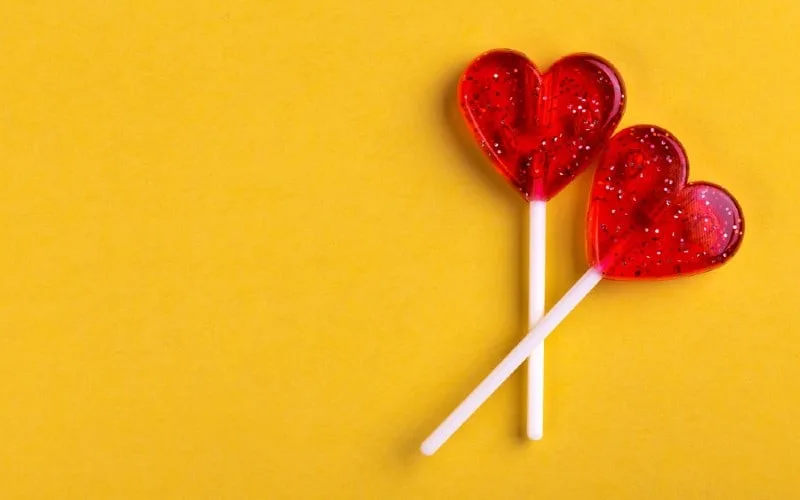 Two crossed lollipops in shape of red hearts