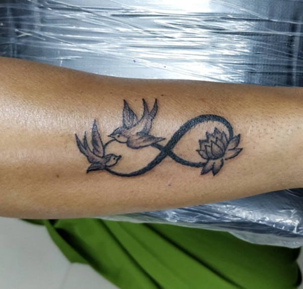 tatuaggio da braccio con loto e due uccelli volanti