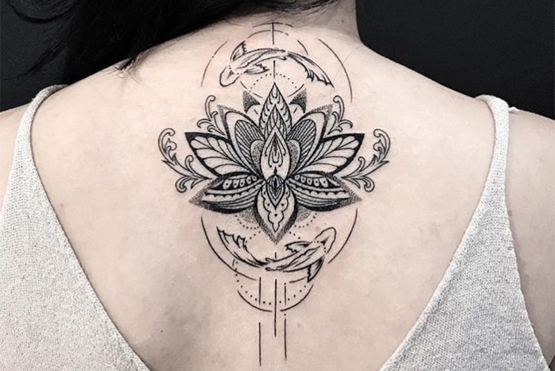 lotus flower and pisces tattoo on woman`s back