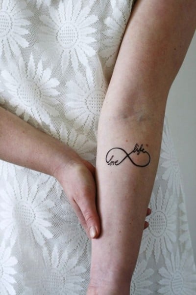 tatuaggio con disegno amore e vita sull'avambraccio
