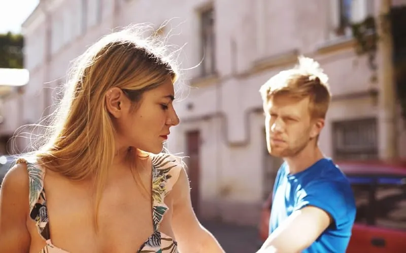 Man and woman breaking up outdoors