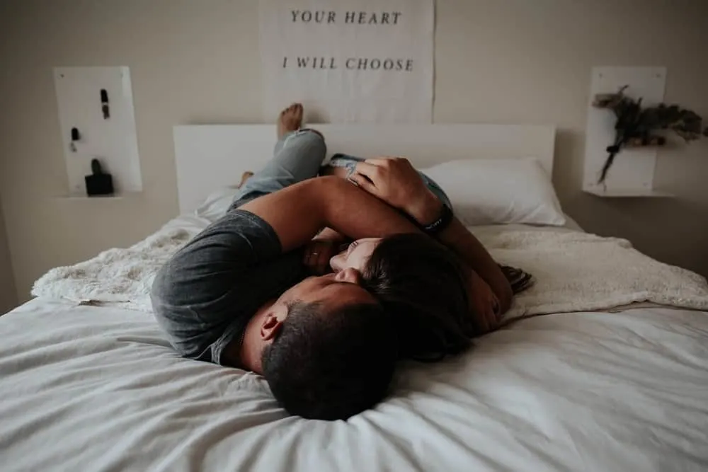 man and woman cuddling in the bed