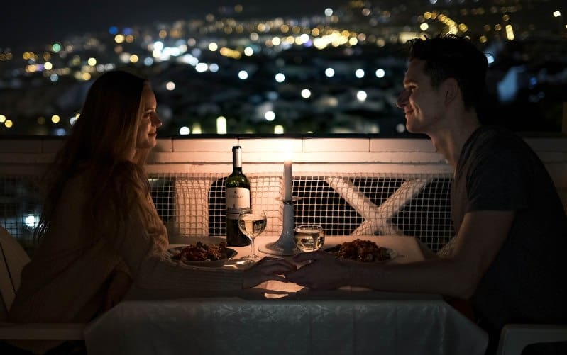 man and woman dining at a table outdoors during nighttime