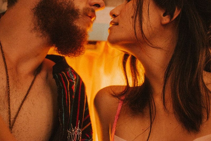 man and woman facing each other about to kiss inside a room