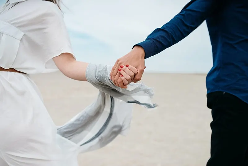 man and woman holding hands together during daytime