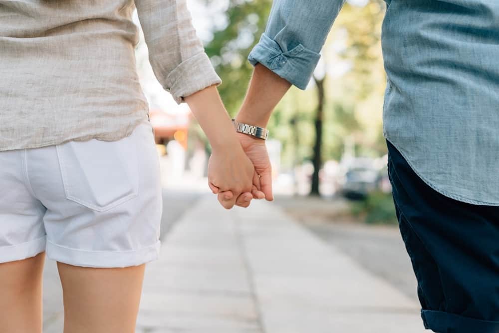 man and woman holding hands together in the morning