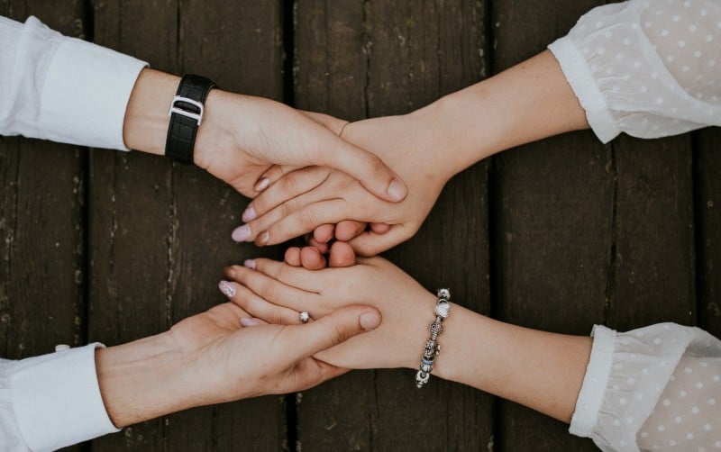 Uomo e donna che si tengono per mano su un tavolo