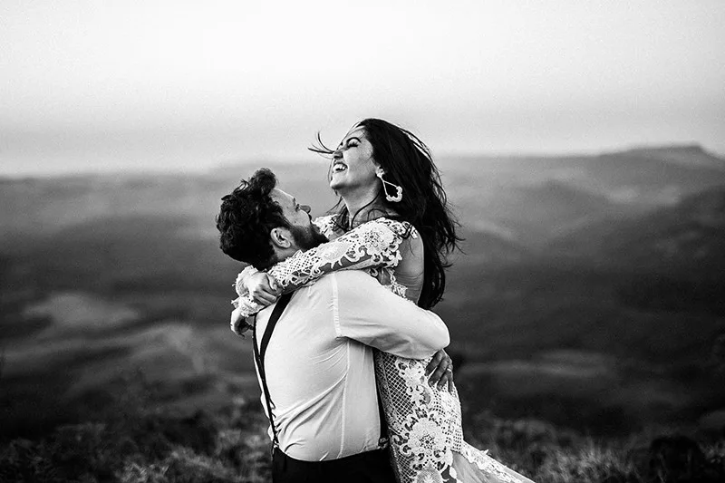 man and woman hugging near hill