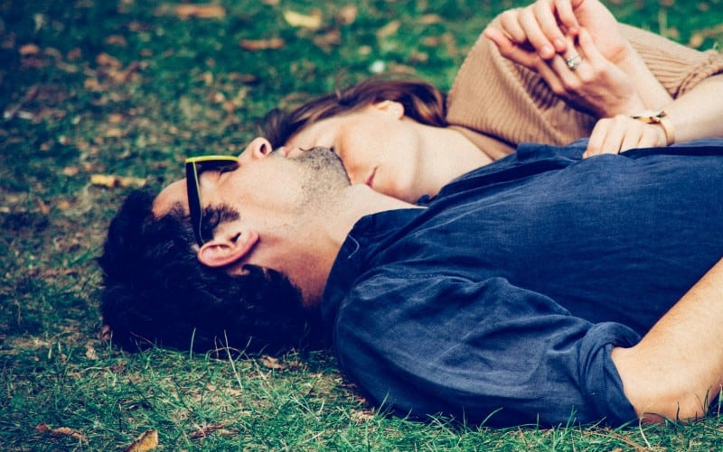 Man and woman lying on grass during daytime