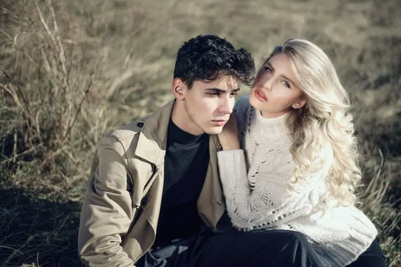 man and woman on grassfield sitting 