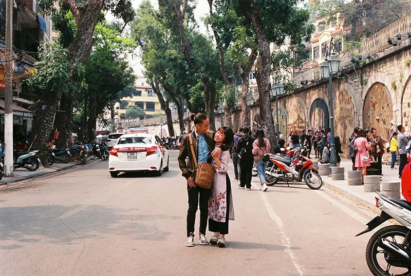 man and woman standing on the street while hugging each other