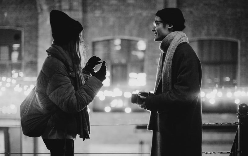 Uomo e donna che parlano per strada di sera