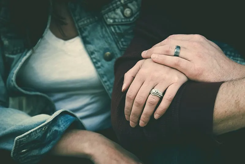 man and woman wearing their silver couple bond ring while holding hands