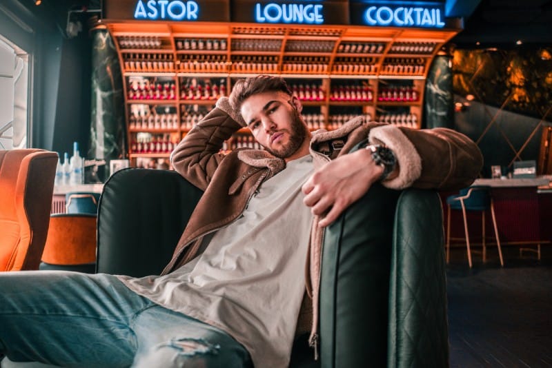 man sitting on green chair at bar