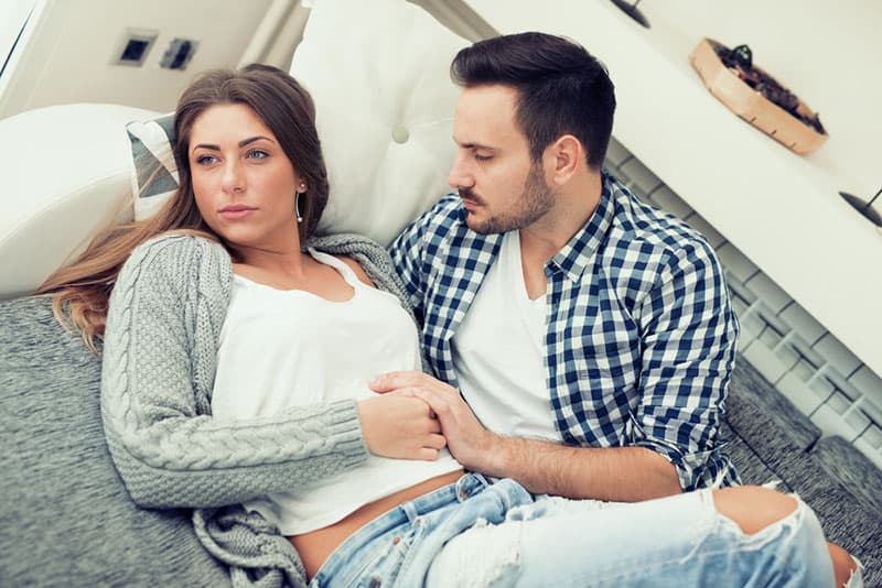 man cuddles worried woman