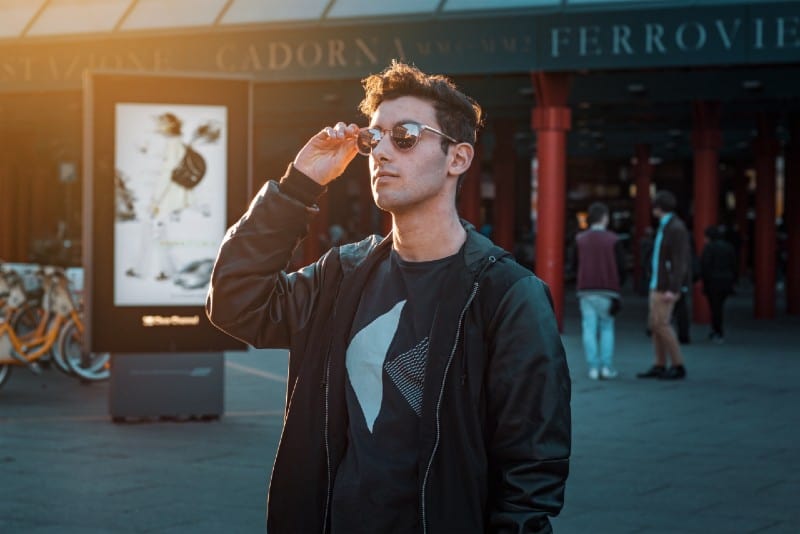 hombre con chaqueta negra con cremallera y gafas de sol