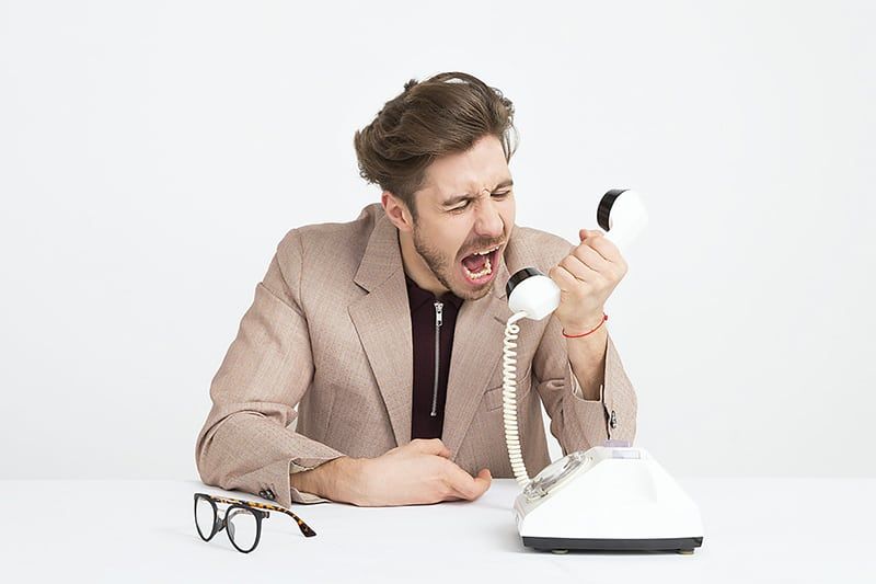 man holding telephone and screaming