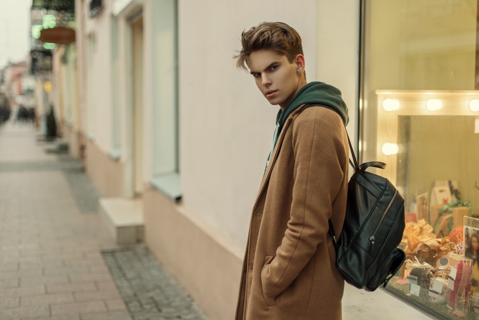 man in a fashion coat with a stylish leather bag