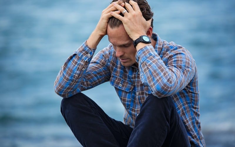 Depressed man in blue and brown shirt