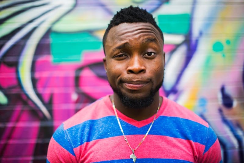 hombre de pelo negro con collar haciendo cara al aire libre