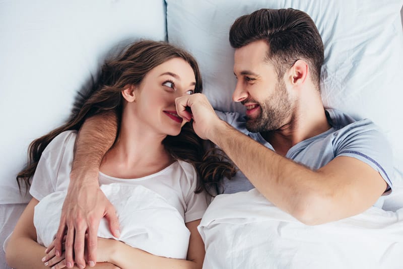 Uomo pizzica il naso della donna mentre è a letto