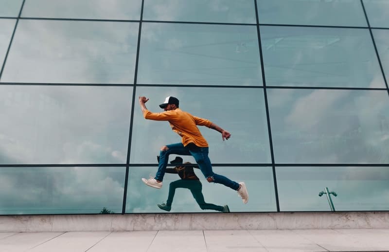 man running or leaping with reflection that mirrored from the glass window of the building