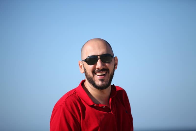 smiling man wearing red polo shirt