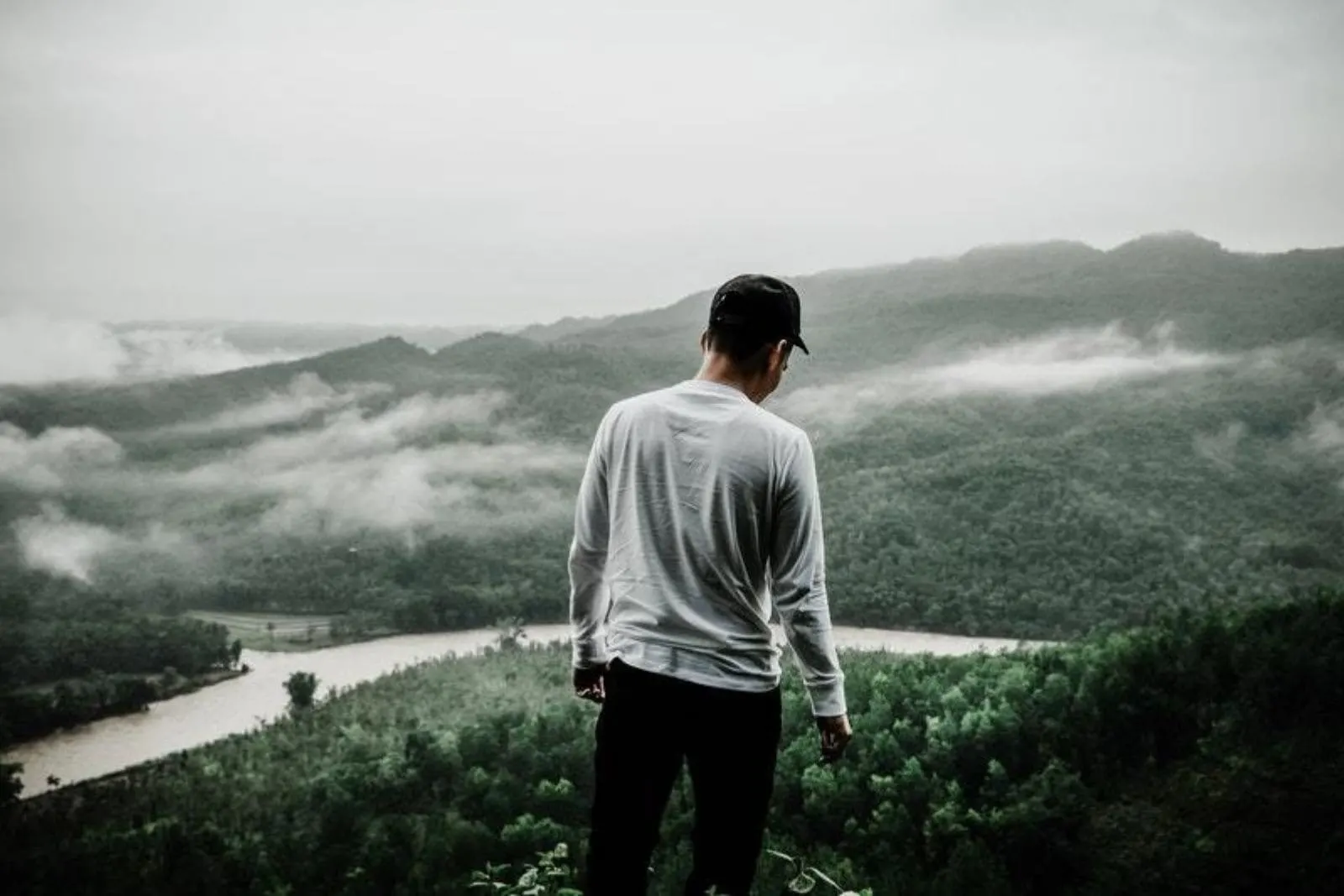 man standing outside in front of hills