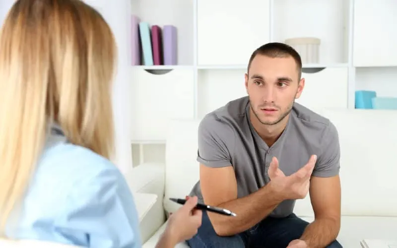 Man talking to a psychologist woman sitting in front of her